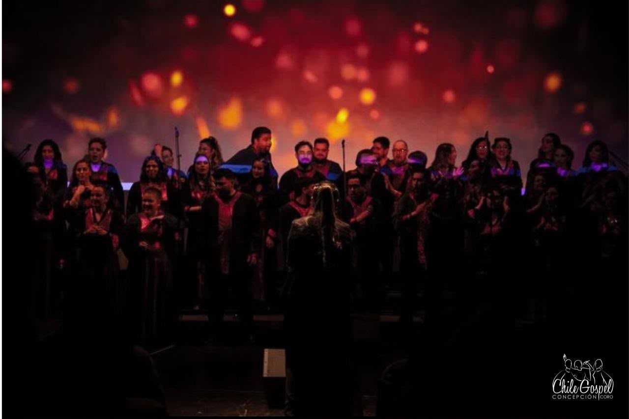 Coro bajo una puesta de luces rojas y doradas
